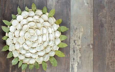 Meat dumplings - russian pelmeni on a round plate and wooden background. Top viewの写真素材