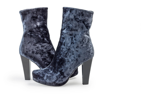A pair of gray suede women's boots on heels standing on white backgroundの写真素材