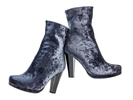 A pair of gray suede women's boots on heels standing on white backgroundの写真素材