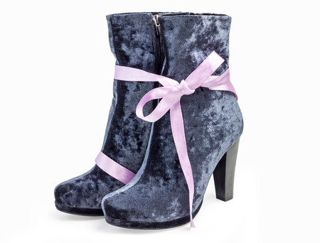 A pair of gray suede women's boots on heels standing on white backgroundの写真素材