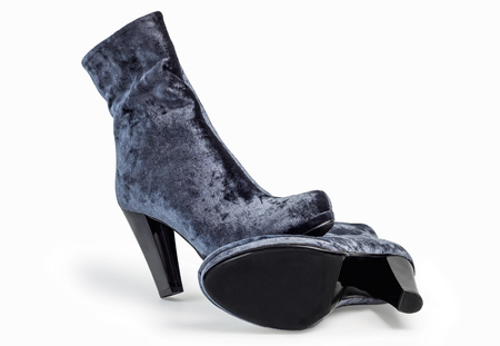 A pair of gray suede women's boots on heels standing on white backgroundの写真素材