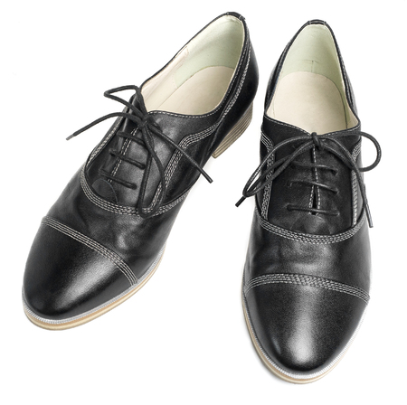 A pair of classic black leather shoes with laces isolated on white backgroundの写真素材