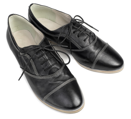 A pair of classic black leather shoes with laces isolated on white backgroundの写真素材