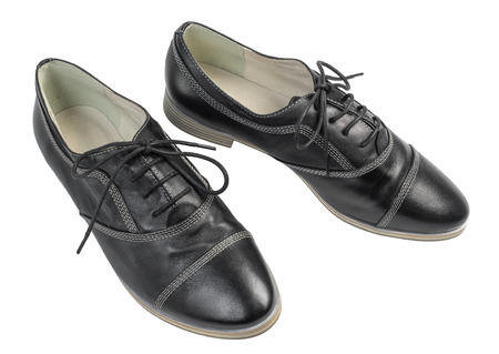 A pair of classic black leather shoes with laces isolated on white backgroundの写真素材