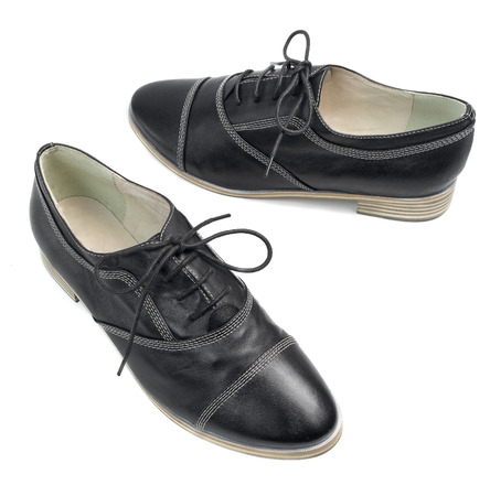 A pair of classic black leather shoes with laces isolated on white backgroundの写真素材