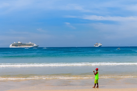 A man takes a photo on your smartphone on a tropical beachの写真素材