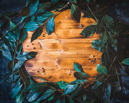 flat lay background with fresh laurus leaves on wooden cutting board.の写真素材
