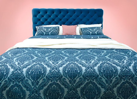 Blue bed furniture with patterned bed linen . Soft velour fabric bed. Classic modern furniture on...