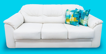 White eco leather sofa with blue pillow. Soft snow white couch with coach-type screed capitone. Classic divan on isolated backgroundの写真素材