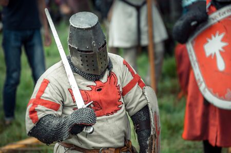 RITTER WEG, MOROZOVO, APRIL 2017: Festival of the European Middle Ages. Portrait of medieval knight in helmet and chain mail battle on swords with shield in their hand.のeditorial素材