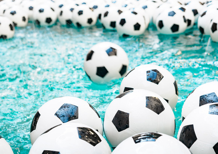 Many black and white soccer balls background. Football balls in a waterの写真素材