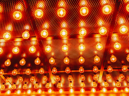 Many bright glowing glass lamps. Illumination of set Edison retro lamps on dark rabitz background. Fashionable loft design with Fashionable loft design with Edison bulbs. Abstract industrial backgroundの写真素材