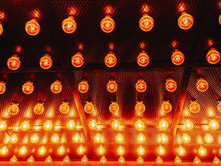 Many bright glowing glass lamps. Illumination of set Edison retro lamps on dark rabitz background....