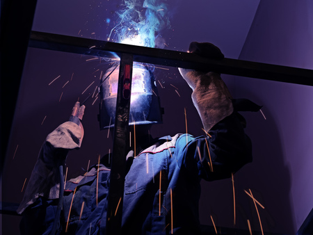 Welder Worker Performs Jump Welding. Worker Welder Performs Arc-Welding Process of Metal Structures....