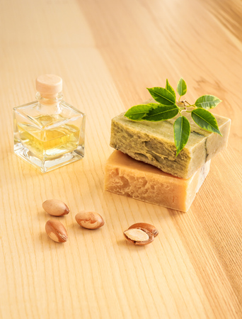 Bottles with cosmetic oil argan nuts. Cosmetic means. Food product. Jar with argan oil and handmade soap on the wooden backgroundの写真素材