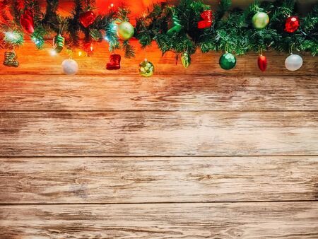 Christmas fir tree garland with christmas tree decoration on wooden board. Bright Christmas and New Year background with empty space for textの写真素材
