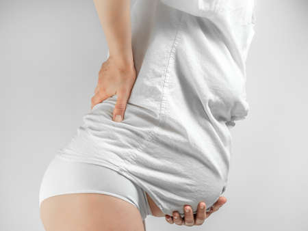 Pregnant woman suffering back ache. Lady in the third trimester of pregnancy. A pregnant young woman...