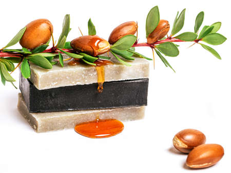 Cosmetic means: cosmetic oil, argan nuts and handmade soap on isolated background.の写真素材