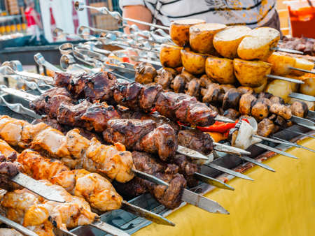 Cooking shashlik on a metal skewer and grilled vegetables. Grilled meat and vegetables. Delicious street food.の写真素材