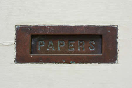 The word  PAPERS  written on a rusty plate