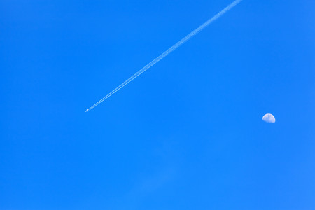 blue sky with plane and moonの写真素材
