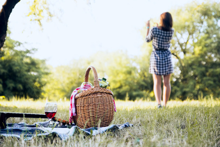 Picnic basket and girl in backgroundの写真素材