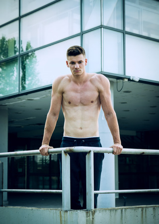Young man prepares for hard training in front of sport center.の写真素材