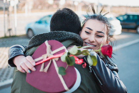 Girl hugs her boyfriend because she is so happy about presents.の写真素材