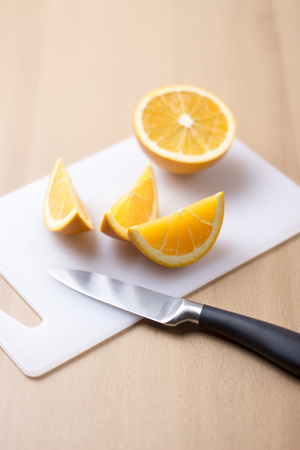 Sliced orange on wooden background - vertical imageの写真素材