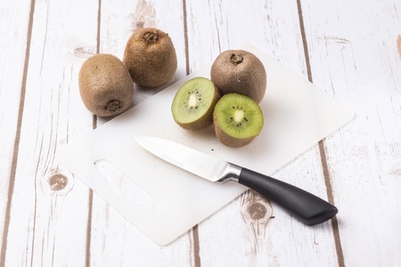 Fresh kiwi fruits on white wooden background - horizontal imageの写真素材