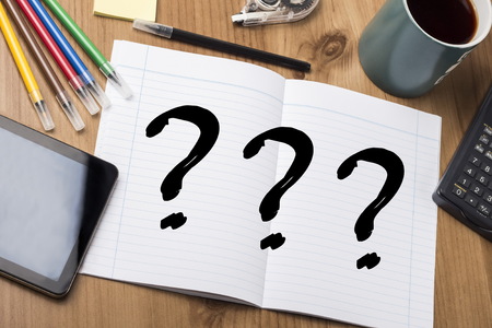 Three question marks - Note Pad With Text On Wooden Table - with office  tools