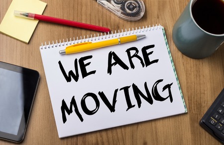 WE ARE MOVING - Note Pad With Text On Wooden Table - with office  toolsの写真素材