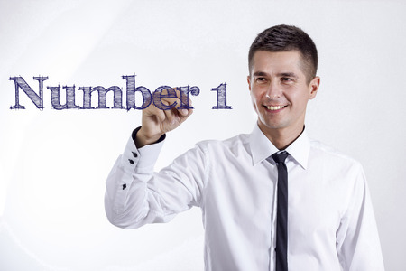 Number 1 - Young smiling businessman writing on transparent surface - horizontal imagesの写真素材