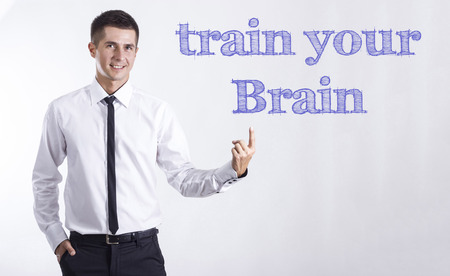 Train your Brain - Young smiling businessman pointing on text - horizontal imagesの写真素材