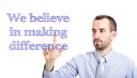 We believe in making difference Young businessman with small beard touching text - horizontal imageの写真素材
