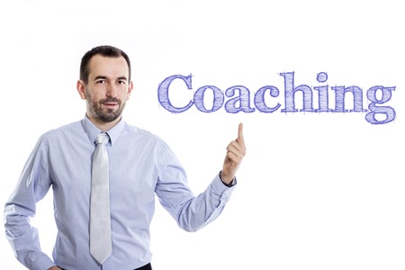 Coaching - Young businessman with small beard pointing up in blue shirt - horizontal imageの写真素材