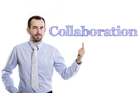 Collaboration - Young businessman with small beard pointing up in blue shirt - horizontal imageの写真素材