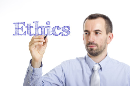 Ethics - Young businessman writing blue text on transparent surface - horizontal imageの写真素材