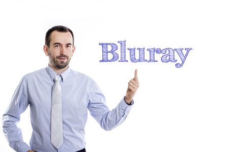 Bluray - Young businessman with small beard pointing up in blue shirt - horizontal imageの写真素材