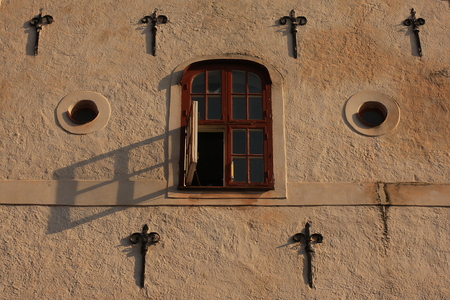 Facade of a historic building with an open window at sunsetの写真素材