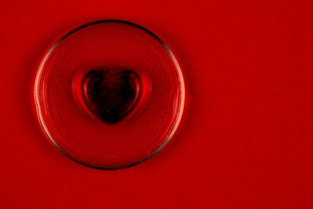 Abstract black heart on red background as a symbol of Valentine dayの写真素材
