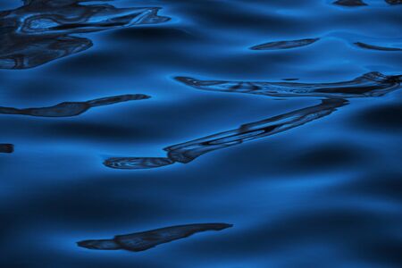 Water surface with reflections in cityscape for background. Classic blue - trend color of 2020
