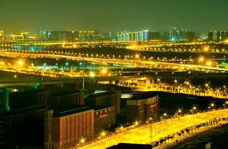A brightly lit road in the city at nightの写真素材