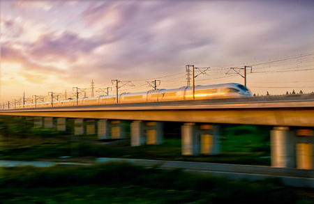 A speeding train on an elevated sunsetの写真素材