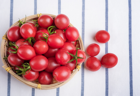 Cherry tomatoes in bamboo basketの写真素材