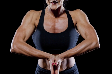 Female bodybuilder working out isolated on blackの写真素材
