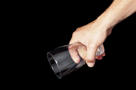 Man holding empty beer glass in hand, isolated on blackの写真素材