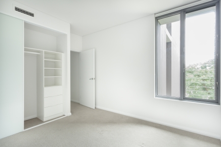 Empty bedroom with wardrobe and windowの写真素材