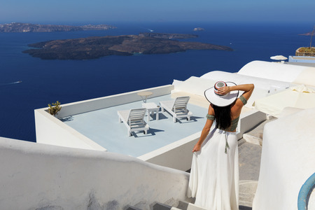 Stylish attractive woman standing in sunny Santorini, Greeceの写真素材