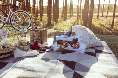 Romantic picnic set up with mixed food platter and wine at sunsetの写真素材
